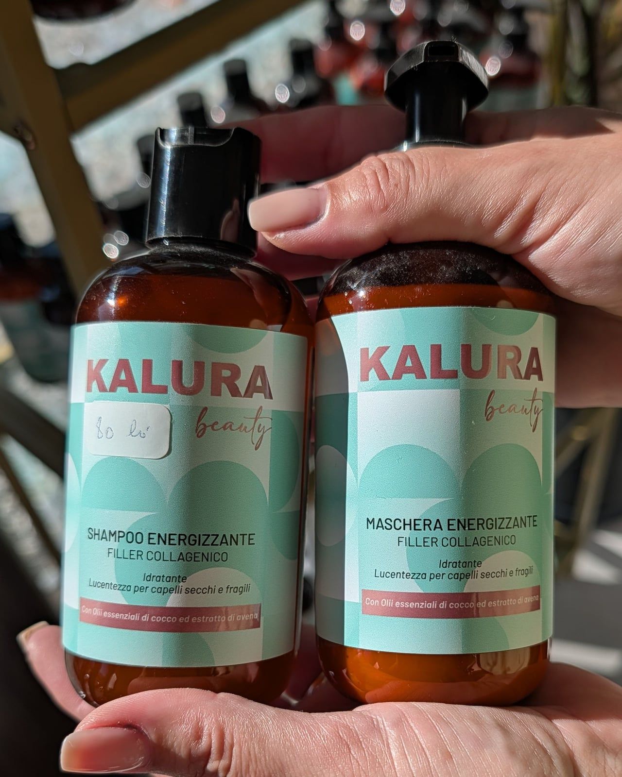 Flacoanele Kalura Beauty Shampoo Energizzante și Maschera Energizzante, ținute în palmă